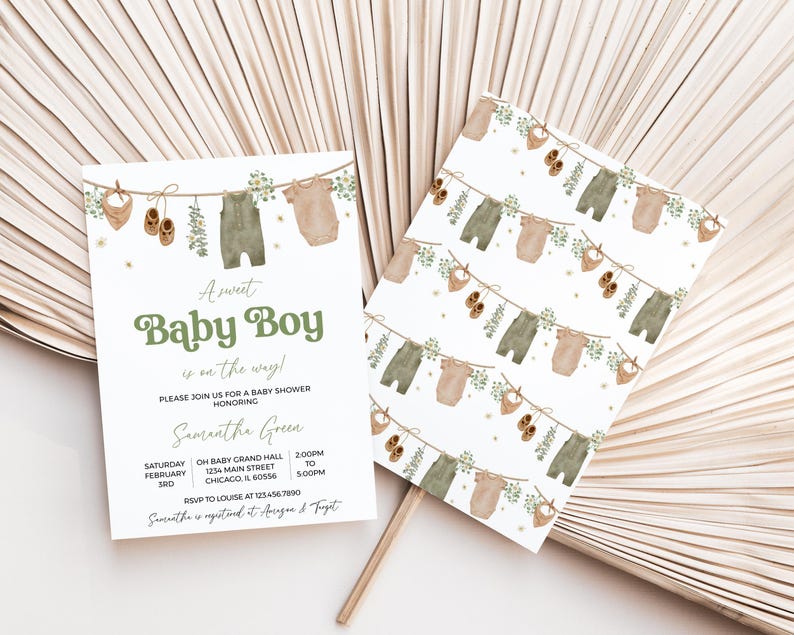 May include: Baby shower invitation and matching card featuring a watercolor design. The invitation reads "A sweet Baby Boy is on the way!" with details for the event. The design includes baby clothes and accessories hanging on a clothesline.