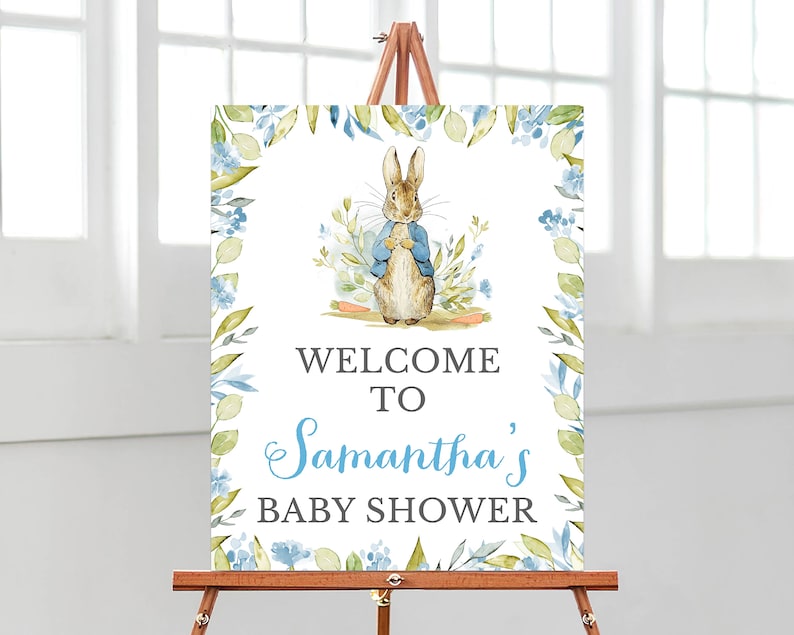 May include: Welcome to Samantha's Baby Shower sign with a watercolor illustration of Peter Rabbit in a blue jacket and a floral border.