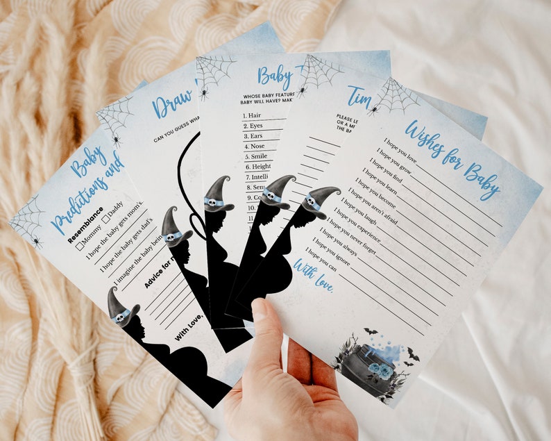 May include: Four blue and white Halloween-themed baby shower game cards with black silhouettes of witches and cauldrons. The cards include games like "Baby Predictions and Resemblance", "Draw", "Baby Wishes for Baby", and "Whose Baby Feature Baby Will Have Mark".