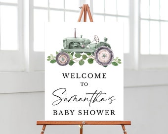 May include: A welcome sign for a baby shower with a green and white tractor illustration and greenery. The sign says "Welcome to Samantha's Baby Shower".