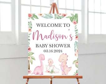 Könnte beinhalten: Willkommen zur Baby Shower von Madison Schild mit rosa und grünen Blumenmustern und rosa Dinosaurier-Illustrationen. Das Datum der Veranstaltung ist der 03.16.2024.