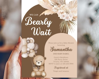 May include: A rectangular baby shower invitation card featuring a brown arch with the text We Can Bearly Wait, a beige arch with event details for Samantha and Baby Isabel, a watercolor teddy bear holding balloons, and dried floral accents.
