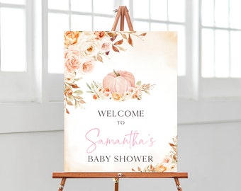 May include: A baby shower welcome sign on an easel. The sign features a watercolor design with a pink pumpkin and floral accents. The text reads "WELCOME TO Samantha's BABY SHOWER" in a mix of fonts and colors.