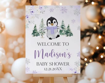 May include: A baby shower welcome sign featuring a cartoon penguin wearing a purple scarf, set against a winter scene with pine trees and snowflakes. The sign reads "Welcome to Madison's Baby Shower 12.21.20XX".