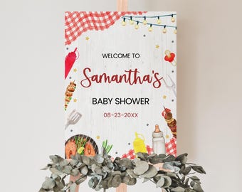 May include: Welcome to Samantha's Baby Shower sign with a red and white checkered background, a wooden plank texture, and illustrations of food, including skewers, hot dogs, and a bottle of ketchup.