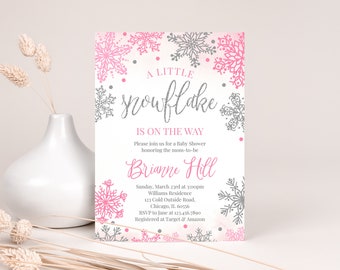 Könnte beinhalten: Eine Babyparty-Einladung mit Schneeflocken-Motiv. Die Einladung zeigt rosa und graue Schneeflocken auf weißem Hintergrund. Der Text "A Little Snowflake Is On The Way" ist in einer dekorativen Schriftart dargestellt.