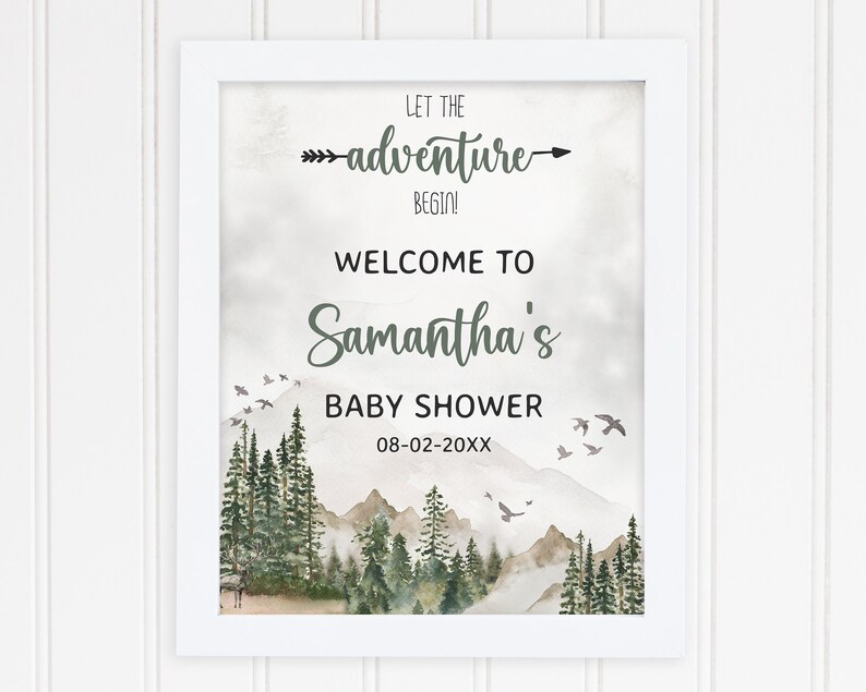 May include: A white framed print with a watercolor illustration of a mountain range with a forest in the foreground. The text "Let the adventure begin!" is at the top of the print, followed by "Welcome to Samantha's Baby Shower 08-02-20XX".