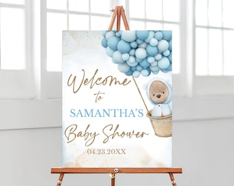 Pode incluir: Bem-vindo ao Chuveiro de Bebê da Samantha sinal com uma ilustração em aquarela de um urso de pelúcia em um balão de ar quente com balões azuis. A data 04.23.20XX está impressa abaixo do texto.