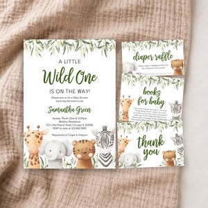 Może przedstawiać: Zestaw zaproszeń na baby shower z akwarelowymi ilustracjami żyrafy, słonia, tygrysa i zebry z zielonymi liśćmi. Tekst zawiera A LITTLE Wild One IS ON THE WAY, diaper raffle, books for baby oraz thank you wraz ze szczegółami wydarzenia.