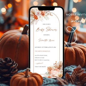 Puede incluir: Un tel&eacute;fono m&oacute;vil muestra una invitaci&oacute;n a un baby shower con elementos florales y bot&aacute;nicos. El texto de la invitaci&oacute;n incluye detalles para el baby shower de Samantha Green. Calabazas, pi&ntilde;as y hojas de oto&ntilde;o rodean el tel&eacute;fono.