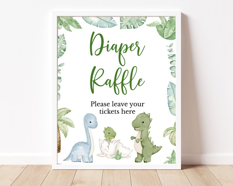 May include: A white sign with green leaves and dinosaurs. The sign says "Diaper Raffle" and "Please leave your tickets here".