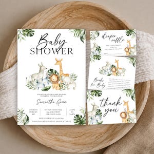 May include: A set of white baby shower stationery featuring watercolor illustrations of a zebra, giraffe, lion, and elephant surrounded by green tropical leaves. The cards include text for a diaper raffle, books for baby, and a thank you note.