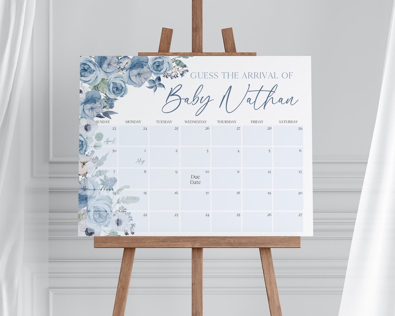 以下が含まれることがあります： 青と白の花柄のベビーシャワーゲーム。ゲームは、「Baby Nathan の到着を予想しよう」というテキストが上部に書かれたカレンダーです。出産予定日はカレンダーに丸で囲まれています。