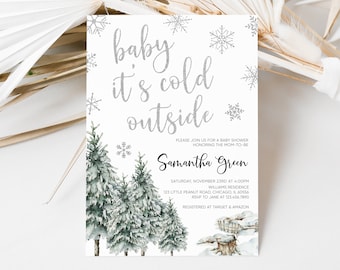 Op de afbeelding: Babyborrel uitnodiging met de tekst "baby it's cold outside" in zilveren glitterscript. De uitnodiging toont aquarel illustraties van met sneeuw bedekte dennenbomen en sneeuwvlokken op een witte achtergrond.