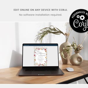 May include: A laptop computer displaying a floral baby shower invitation with the text "A little Wildflower is on the way". The invitation is customizable using the online design platform, Corjl.