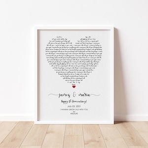 May include: A framed print with a white border features a heart-shaped design composed of song lyrics. The names "James & Maria" are written in cursive, with "Happy 8th Anniversary!" below. The date "July 03, 2021" is also included.