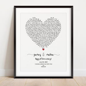May include: A framed print with a black border. The print features lyrics arranged in a heart shape. Below the heart, the names "James & Maria" are written in cursive, followed by "Happy 1st Anniversary!" and the date "July 03, 2021". The song title "I WANNA GROW OLD WITH YOU" is also included.