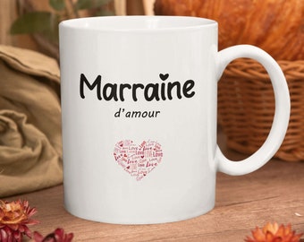 Puede incluir: Taza de cerámica blanca con una inscripción negra que dice "Marraine d'amour" y un corazón rosa relleno con la palabra "love" en una fuente más pequeña.