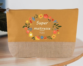 Puede incluir: Una bolsa de cremallera amarilla mostaza con fondo de arpillera marrón. La bolsa tiene un diseño de corona de flores con el texto "Super maitresse Pauline".