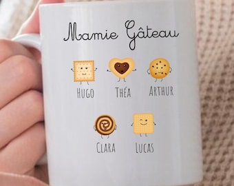 May include: White ceramic mug with the text "Mamie Gâteau" and illustrations of cookies with names Hugo, Thea, Arthur, Clara, and Lucas.