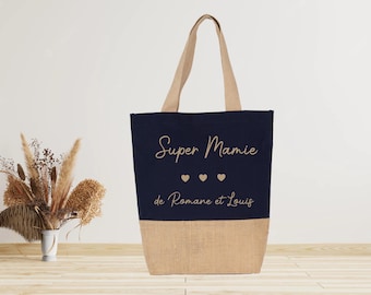 Op de afbeelding: Een blauwe en beige tote bag met de tekst "Super Mamie de Romane et Louis" en drie kleine hartjes.