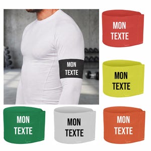 May include: A person wearing a white long-sleeve shirt with a black arm band that says "MON TEXTE" in white. Additional arm bands in red, yellow, green, white, and orange are also shown, each with the same text.