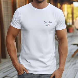 May include: White t-shirt with the text "Beau-Pere" and a small red heart.