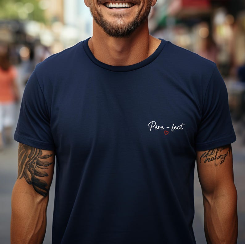 May include: Navy blue crew neck t-shirt with the text "P&egrave;re-fect" in white script and a small red heart. The shirt has short sleeves and a classic fit.