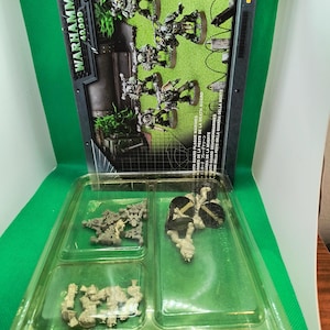 May include: A plastic tray containing unpainted miniature figures of space marines. The figures are in various poses and are ready to be assembled and painted. The tray is labeled "Death Guard Plague Marines".