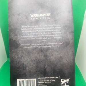 May include: A black book cover with the title "Warhammer Chronicles" and a description of the book's contents. The back cover also includes the book's ISBN, price, and publisher information.