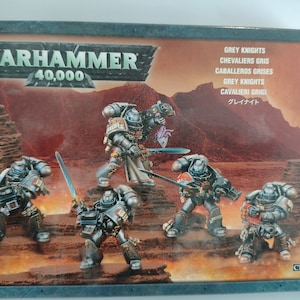 May include: A box of Grey Knights miniatures for the Warhammer 40,000 tabletop game. The box features a depiction of five Grey Knights in combat, with a desert-like background.