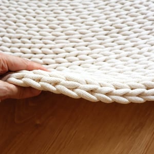 Grof roomwit rond tapijt, dik en zacht tapijt voor slaapkamer, ongebruikelijke decoratie voor interieur, esthetisch woonkameraccent.