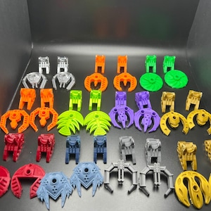 May include: A collection of colorful plastic toy parts in various shapes and sizes. The pieces are in shades of orange, green, purple, red, blue, silver, and gold. Some pieces resemble claws, while others are circular or have a mechanical design.