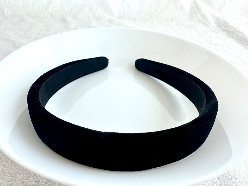 May include: A black velvet headband on a white plate.