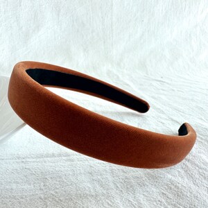 May include: A brown velvet headband with a black elastic band.