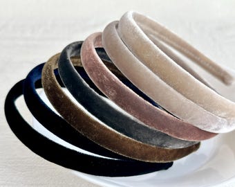 May include: A set of eight velvet headbands in various colors, including black, brown, gray, and pink. The headbands are all made of a soft, stretchy material and are perfect for adding a touch of elegance to any outfit.