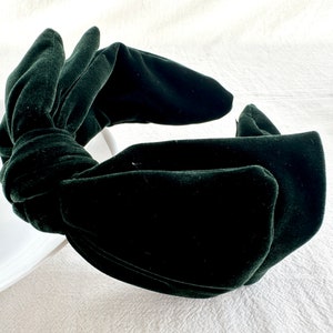 Puede incluir: Una diadema de terciopelo verde oscuro con un gran lazo. La diadema está hecha de terciopelo suave y afelpado y es perfecta para añadir un toque de elegancia a cualquier atuendo.