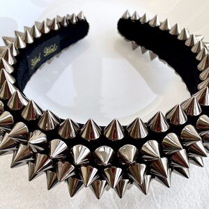 May include: A black headband with silver metal spikes. The headband is hand-made.