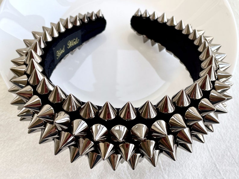 May include: A black headband with silver metal spikes. The headband is hand-made.
