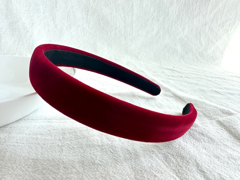 May include: A wide, burgundy velvet headband with a black elastic band on the inside.