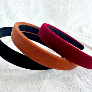 May include: Three velvet headbands in black, brown, and burgundy.