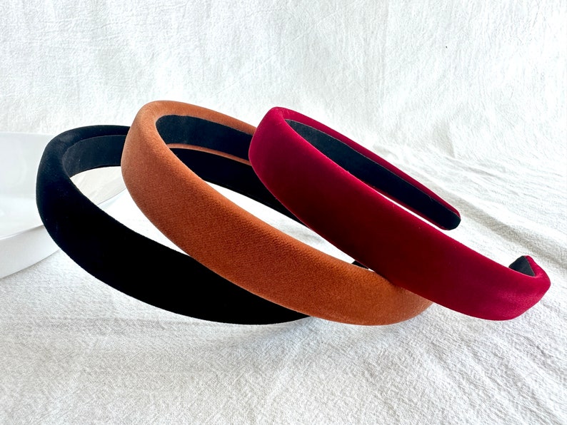 May include: Three velvet headbands in black, brown, and burgundy.