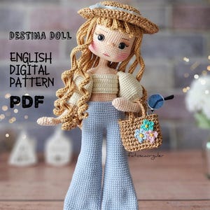 Puede incluir: Muñeca de ganchillo con pelo largo y ondulado rubio, que lleva un sombrero de paja, un top color crema y pantalones acampanados azul claro. La muñeca lleva un pequeño bolso y gafas de sol. El texto en la imagen dice "DESTINA DOLL ENGLISH DIGITAL PATTERN PDF".