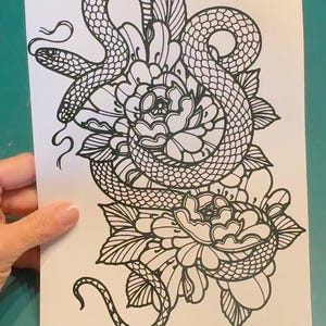 May include: Black and white line art illustration of a snake wrapped around a flower. The snake is curled around the flower, with its head and tail visible. The flower has multiple petals and leaves.