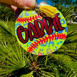 May include: A yellow and white softball keychain with a red glitter name "GABBIE" and a yellow tassel.