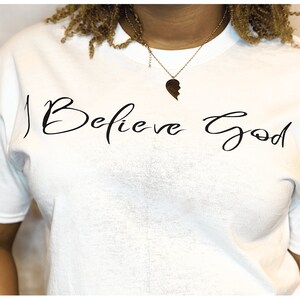 Las camisetas I Believe God White están disponibles en varios colores de fuente.