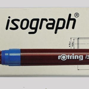 Può includere: Una penna tecnica Rotring Isograph e il suo cappuccio sono esposti su una scatola color crema. La penna è rosso scuro con un'impugnatura blu e punta argentata. La scatola presenta il logo Rotring e disegni tecnici.