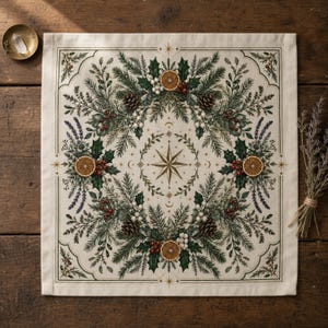 May include: A square off-white fabric cloth featuring a central gold star emblem surrounded by a wreath of green pine branches, holly leaves, red berries, white berries, dried orange slices, and lavender sprigs, all enclosed within a thin border.