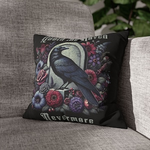 May include: Black throw pillow with a raven perched on a tombstone surrounded by flowers. The text "Quoth the raven Nevermore" is printed on the pillow.