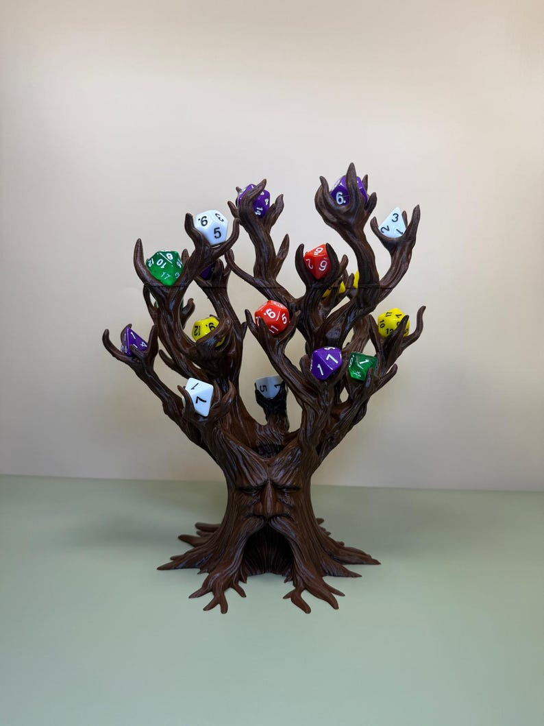 Pu&ograve; includere: Un porta dadi a forma di albero marrone con un volto scolpito nel tronco. I rami sostengono dadi multicolori, verdi, viola, rossi e gialli. I dadi sono numerati, per giochi da tavolo.